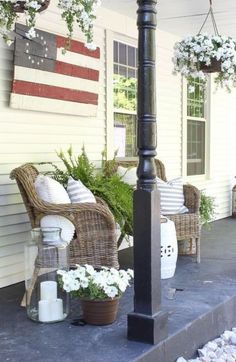 the porch is decorated with wicker chairs and an american flag