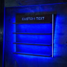 a blue light shines on the side of a wall with a sign that reads custom text