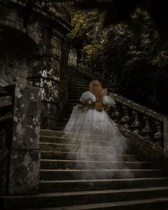 a woman in a white dress is walking down stairs with her back to the camera