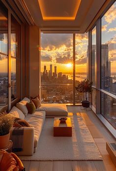 a living room filled with lots of furniture and tall buildings in the background at sunset