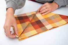 a person is cutting fabric on a piece of cloth