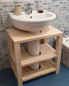 a white sink sitting on top of a wooden stand