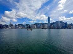 the city skyline as seen from across the water with boats on it and mountains in the background