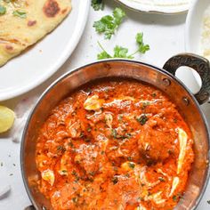 a pan filled with food on top of a table next to other plates and utensils