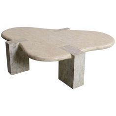 a white marble coffee table with an oval shaped design on the top and two curved legs