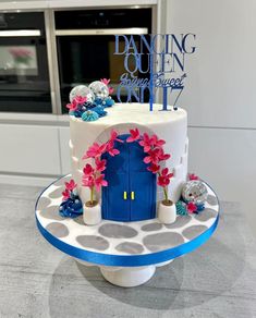 a white cake with blue and pink decorations on it's side sitting on top of a counter