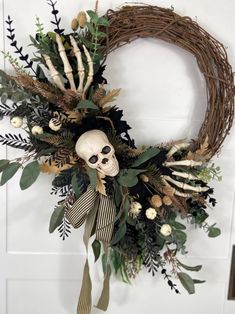 a wreath with a skeleton head and flowers on the front door is decorated with greenery