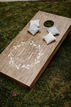 a close up of a cornhole board on the grass with pillows and napkins