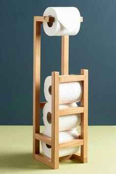 a wooden rack with four rolls of toilet paper on it and one roll in the holder