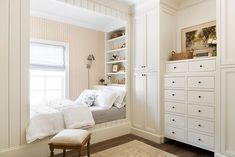 a bedroom with white furniture and wallpaper on the walls