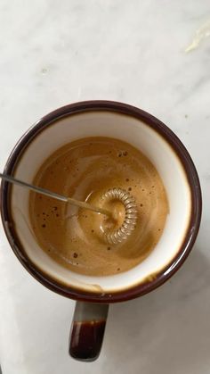 an overhead view of a coffee cup with a spoon in it