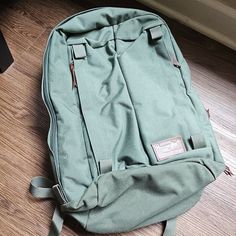 a green backpack sitting on the floor