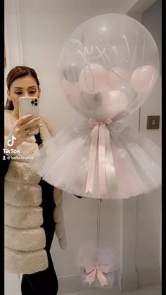 a woman taking a selfie in front of a balloon