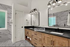 a bathroom with marble counter tops and double sinks, mirrors on the wall and lights above them