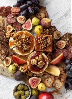 an assortment of fruits, nuts and crackers on a white table top with text overlay