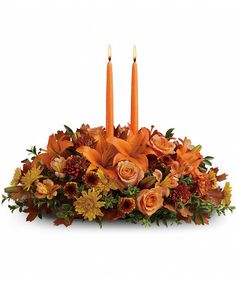 an orange centerpiece with candles and flowers