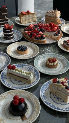 a table topped with lots of different types of cakes and desserts covered in frosting