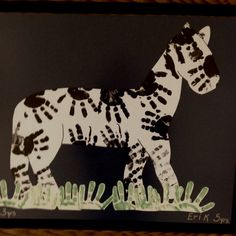 a paper cut out of a zebra standing in the grass on a black background,