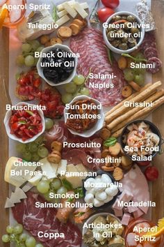 a wooden table topped with lots of different types of meats and cheeses on it