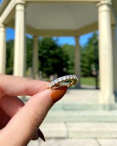 a person holding a ring in front of a gazebo