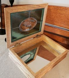 an open wooden box with glass in it