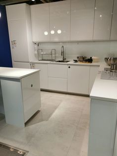 an empty kitchen with white cabinets and counter tops in the middle of the flooring