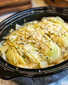 a bowl filled with cabbage and topped with parmesan cheese