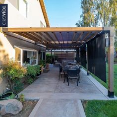 an outdoor patio with table and chairs under a pergolated awning over it