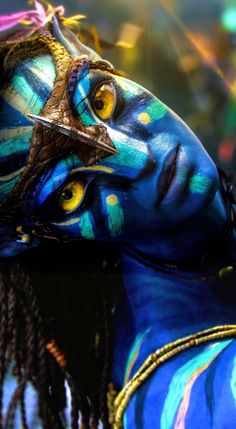 a woman's face painted with blue and yellow