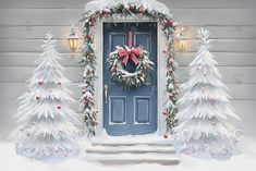 a blue front door decorated for christmas with wreaths and pine trees in the snow