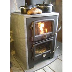 an old fashioned wood burning stove with some bread on it's burner and oven door open