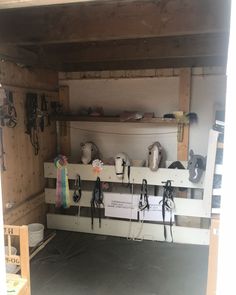 the inside of a shed with several horse tacks