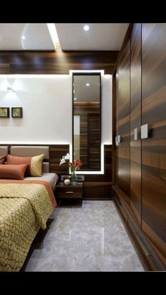 a bed sitting in a bedroom next to a wooden dresser and wall mounted mirror with lights on it