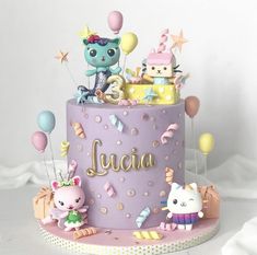 there is a purple cake with kittens and balloons on the top it says juan