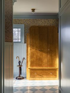 an open door leading to a room with wooden cabinets