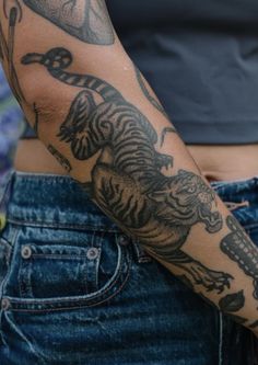 a woman with tattoos on her arm holding a cell phone