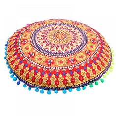 a round pillow with pom poms on it and a circular design in the middle