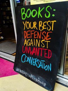 a chalkboard sign that reads books your best defense against unwanted conversation on the sidewalk