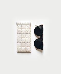 the sunglasses and case are next to each other on a white surface with a pair of black glasses