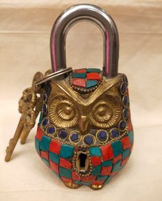 an owl shaped padlock with two keys attached to it