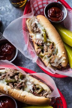 two hot dogs in baskets with pickles and ketchup