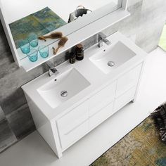 a bathroom vanity with two sinks and a large mirror over the sink is next to a rug on the floor