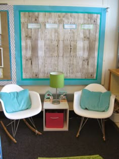 two white chairs sitting next to each other in front of a wooden paneled wall