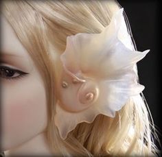 a close up of a mannequin's head with a flower on it