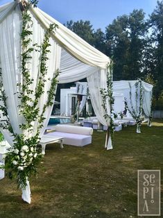 an outdoor wedding setup with white linens and greenery on the arbor, next to a swimming pool