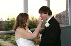 a bride and groom feeding each other cake