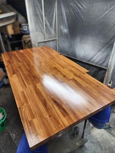 a wooden table sitting on top of a blue barrel