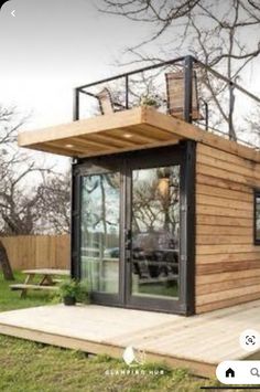 a small wooden house sitting on top of a lush green field