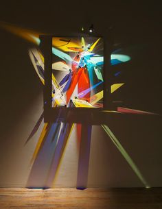 an abstract painting is projected on the wall with light coming from it's back