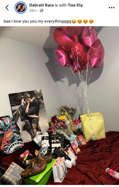 a bed topped with lots of balloons next to pictures and other items on top of it